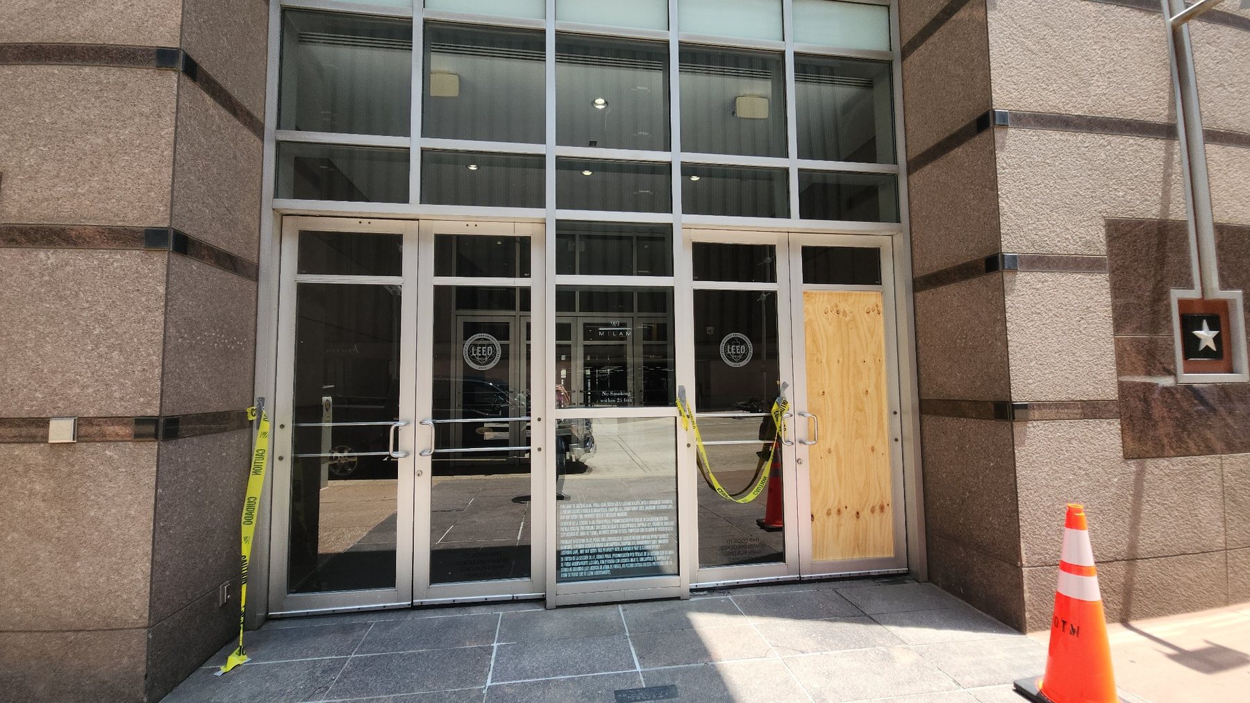 Damaged commercial building entrance with boarded opening